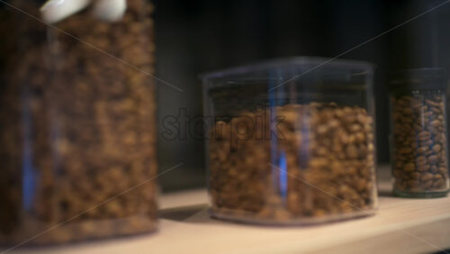 Close up of coffee beans stored inside transparent containers of different heights