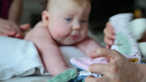 Baby focusing on colorful soft toy during a massage