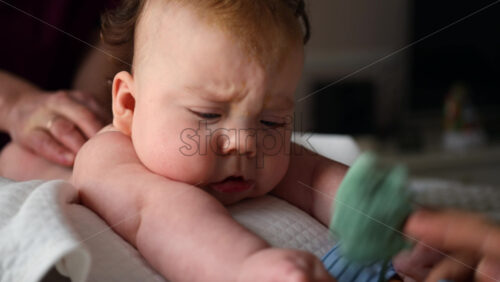Baby focusing on colorful soft toy during a massage