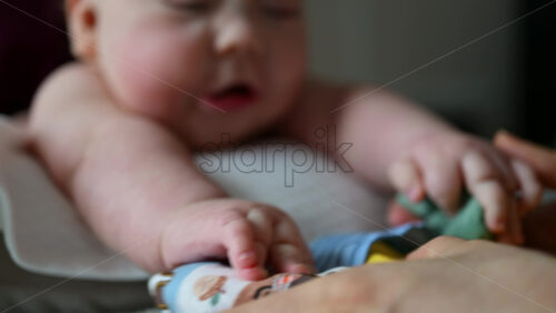Baby focusing on colorful soft toy during a massage