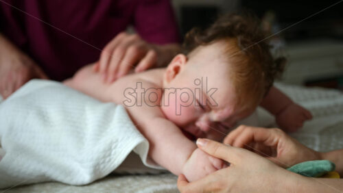 Baby focusing on colorful soft toy during a massage