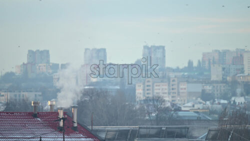 Wide residential cityscape with layered apartment buildings and houses under soft morning haze