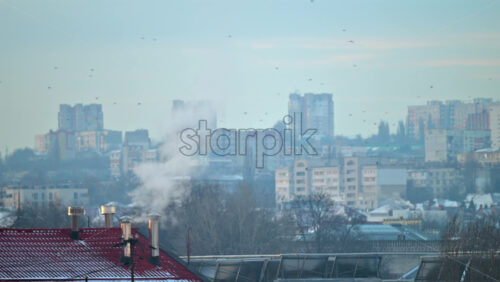 Wide residential cityscape with layered apartment buildings and houses under soft morning haze