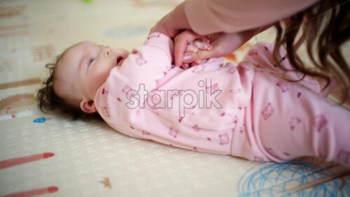 Caregiver guiding the baby's arms upward in a controlled, gentle movement