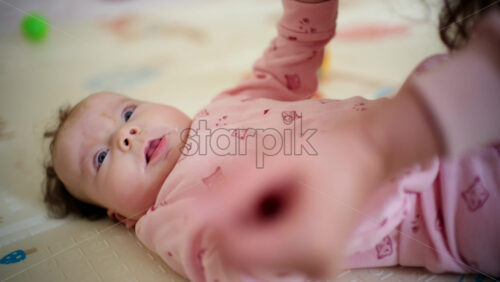 Caregiver guiding the baby's arms upward in a controlled, gentle movement
