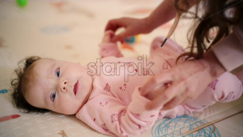 Caregiver holding the baby's arm upright to support movement