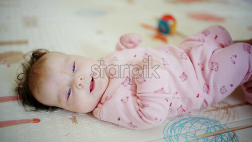 Baby on back while the caregiver gently holds both feet together in a soft stretch position