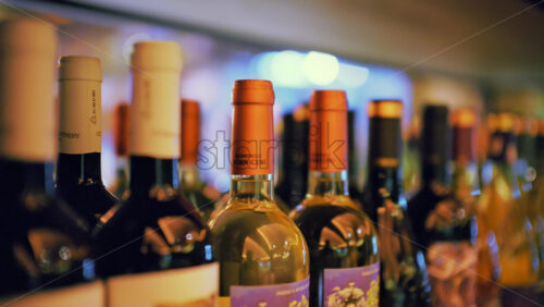 Close up of wine bottles arranged on a shelf in a bar or restaurant