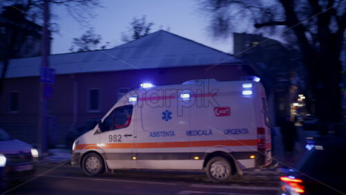 Chisinau, Moldova - January 15, 2026: Ambulance driving through a city street at dusk in winter conditions