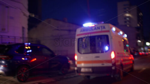 Chisinau, Moldova - January 17, 2026: Ambulance with flashing blue lights approaching along a residential street decorated with warm holiday lights