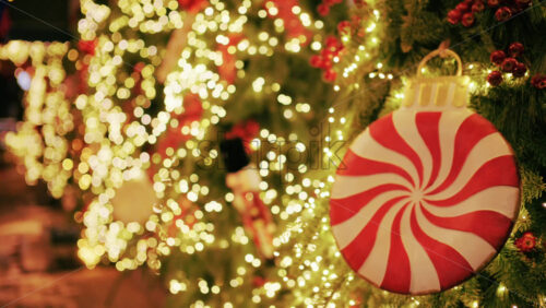 Christmas tree decorated with warm lights and a large red and white peppermint style ornament