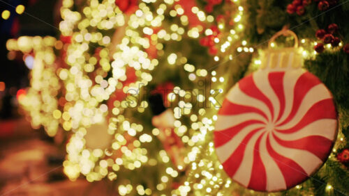 Christmas tree decorated with warm lights and a large red and white peppermint style ornament