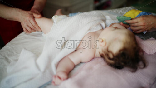 Baby focusing on colorful soft toy during a massage