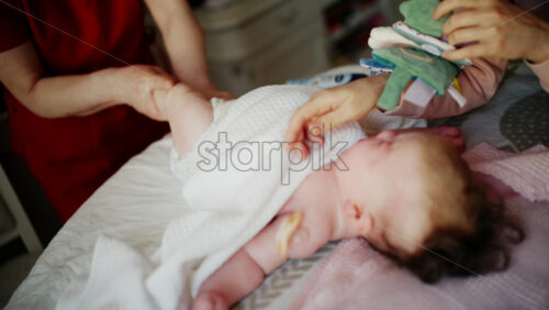Baby focusing on colorful soft toy during a massage