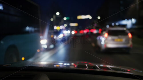Forward facing night drive along a city street with headlights and streetlights blurred
