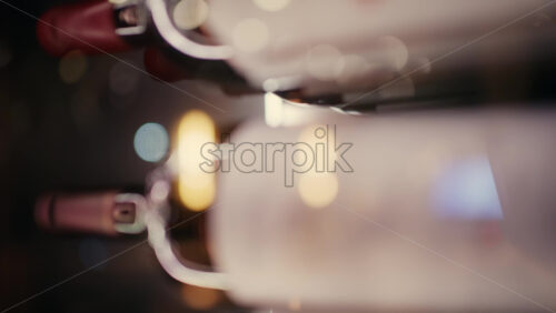 Extreme close up of wine bottles stored horizontally in a rack, with warm lighting and shallow depth of field