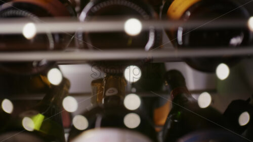 Extreme close up of wine bottles stored horizontally in a rack, with warm lighting and shallow depth of field
