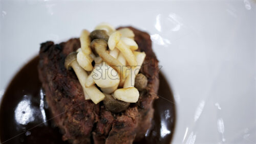Roasted meat served with mushrooms and sauce in an elegant restaurant setting