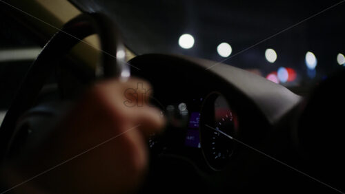 View from inside a car of a night city street with illuminated decorative lights in the distance