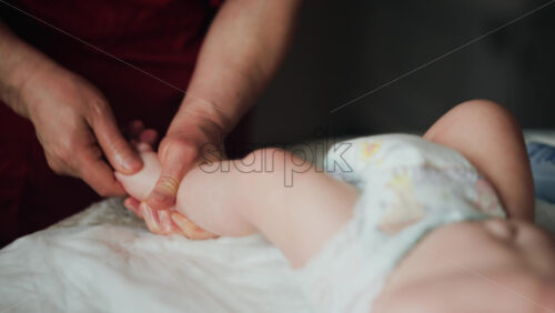 Caregiver doing mobility exercises with a baby