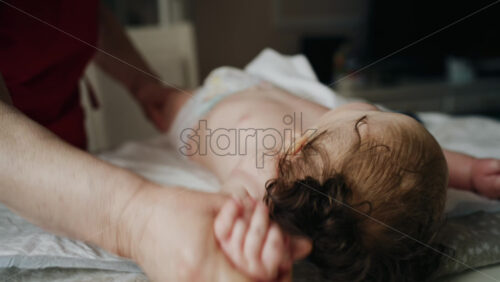 Caregiver doing mobility exercises with a baby