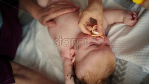 Baby lying on their back while an adult massages them and performs mobility exercises