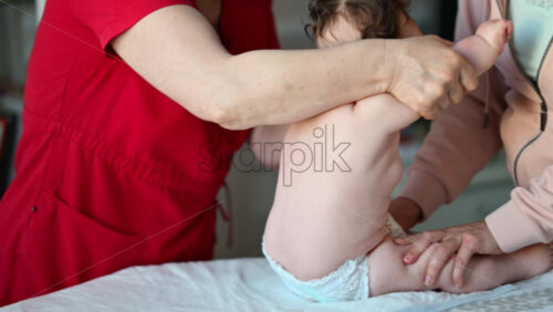 Caregiver doing mobility exercises with a baby