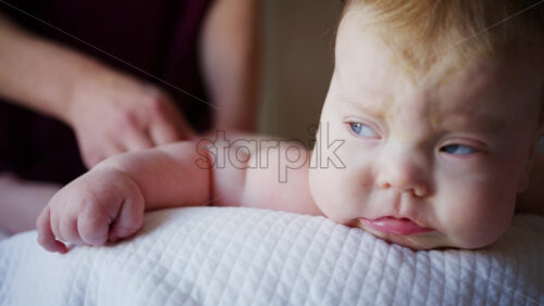 Baby lying on their back while an adult massages them and performs mobility exercises