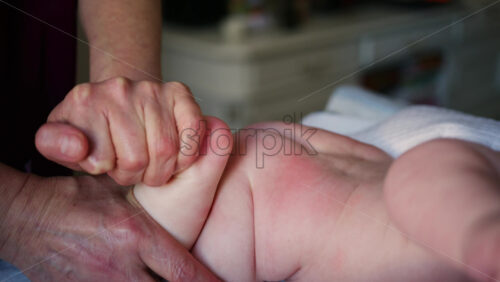 Caregiver doing mobility exercises with a baby
