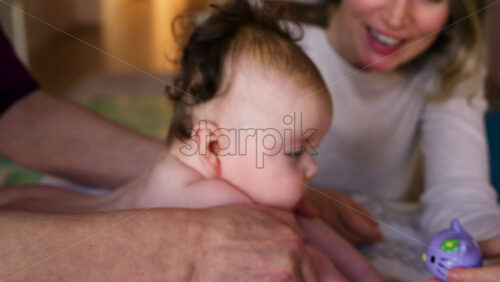 Baby lying on their tummy while an adult massages them and performs mobility exercises