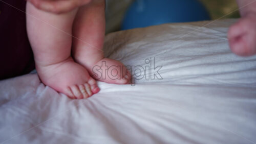 Close up of adult hands gently massaging a baby's foot and sole