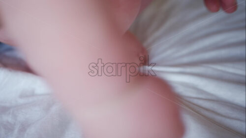 Close up of adult hands gently massaging a baby's foot and sole