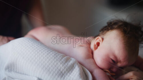 Baby lying on their tummy while an adult massages them and performs mobility exercises