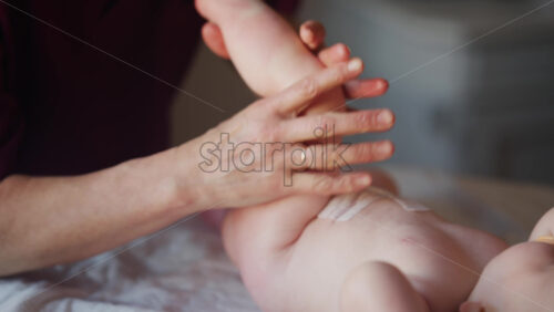 Caregiver doing mobility exercises with a baby