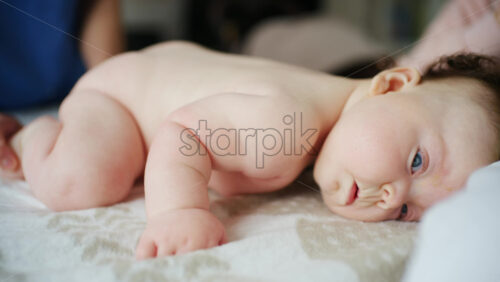 Baby lying on their back while an adult massages them and performs mobility exercises