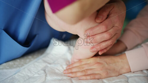 Caregiver doing mobility exercises with a baby