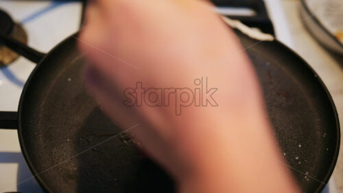 Raw beef steak seasoned with salt placed onto a hot pan
