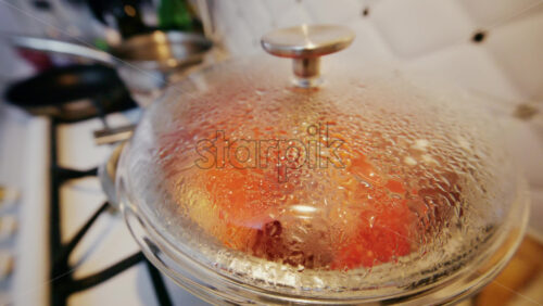 Close up of a glass pot lid covered in condensation as food cooks inside