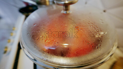 Close up of a glass pot lid covered in condensation as food cooks inside