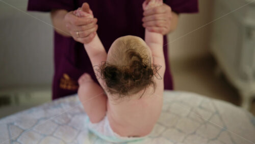 Caregiver doing mobility exercises with a baby