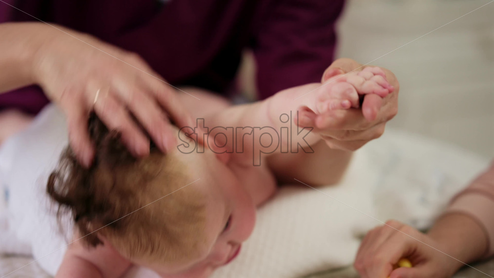 Caregiver doing mobility exercises with a baby