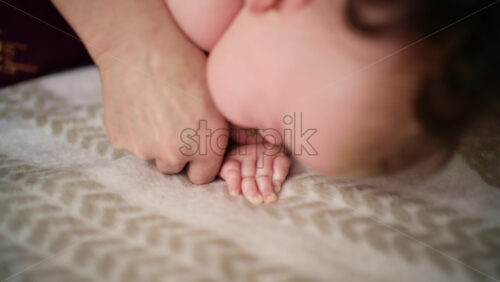 Baby lying on their tummy while an adult massages them and performs mobility exercises