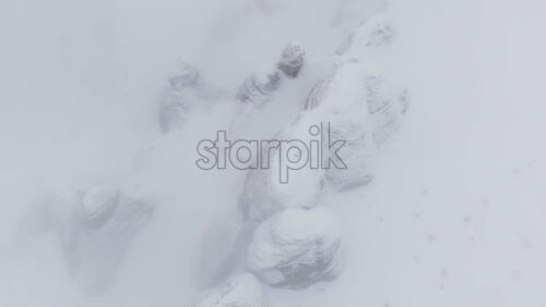 Aerial drone view of rocks covered in snow in winter season. Romania, Carpathian Mountains