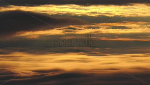 Panoramic aerial drone view of golden sunrise above clouds, winter landscape in the mountains. Transylvania, Mount Ciucas in Romania