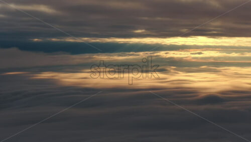 Panoramic aerial drone view of golden sunrise above clouds, winter landscape in the mountains. Transylvania, Mount Ciucas in Romania