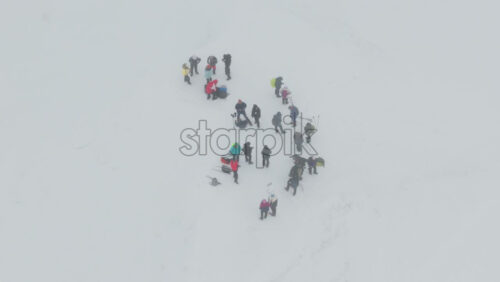 Aerial drone view of people hiking on Ciucas peak covered in snow in winter season. Romania, Carpathian Mountains