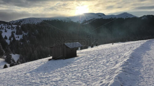 Panoramic aerial drone view of winter landscape at sunrise with snow in the mountains. Transylvania, Mount Ciucas in Romania