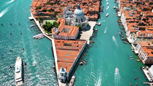Aerial drone view of Venice, Italy. Water channels with multiple floating and moored boats, historical city centre with Santa Maria della Salute and other old buildings and narrow streets Royalty Free Stock Video Footage - Starpik Stock