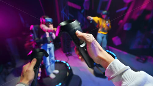 Premium stock video footage – A group of joyful, interested young people playing on VR treadmill with helmets and controllers. POV, virtual reality Download royalty free stock video footage - Starpik Stock