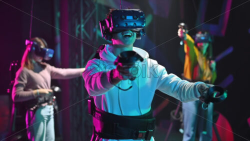 Premium stock video footage – Group of joyful, interested young people playing on VR treadmill with helmets and controllers. Slow motion virtual reality Download royalty free stock video footage - Starpik Stock